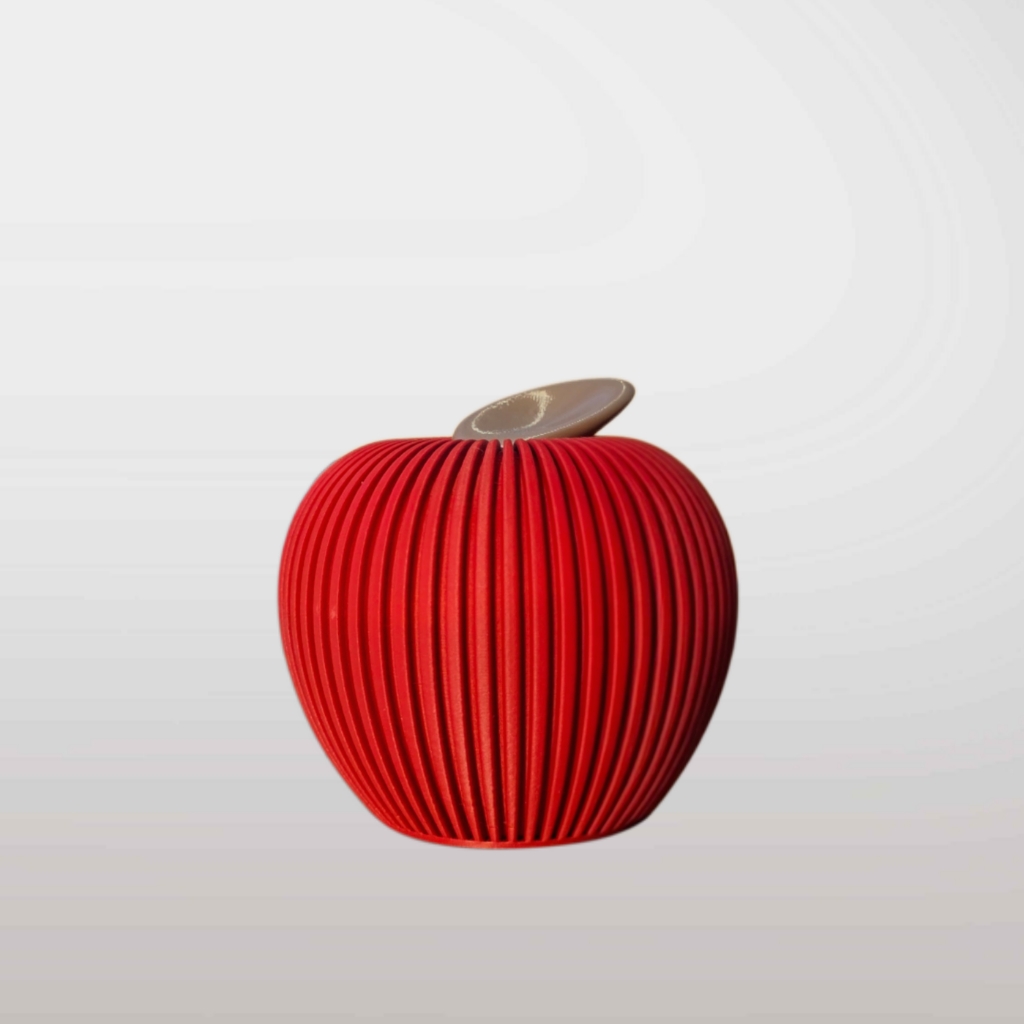Roter Deko-Apfel mit vertikaler Rillenstruktur und braunem Blatt im minimalistischen Japandi-Stil auf hellem Hintergrund.